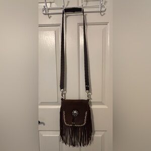 Handcrafted leather fringe bag with hand beaded edge and silver concho